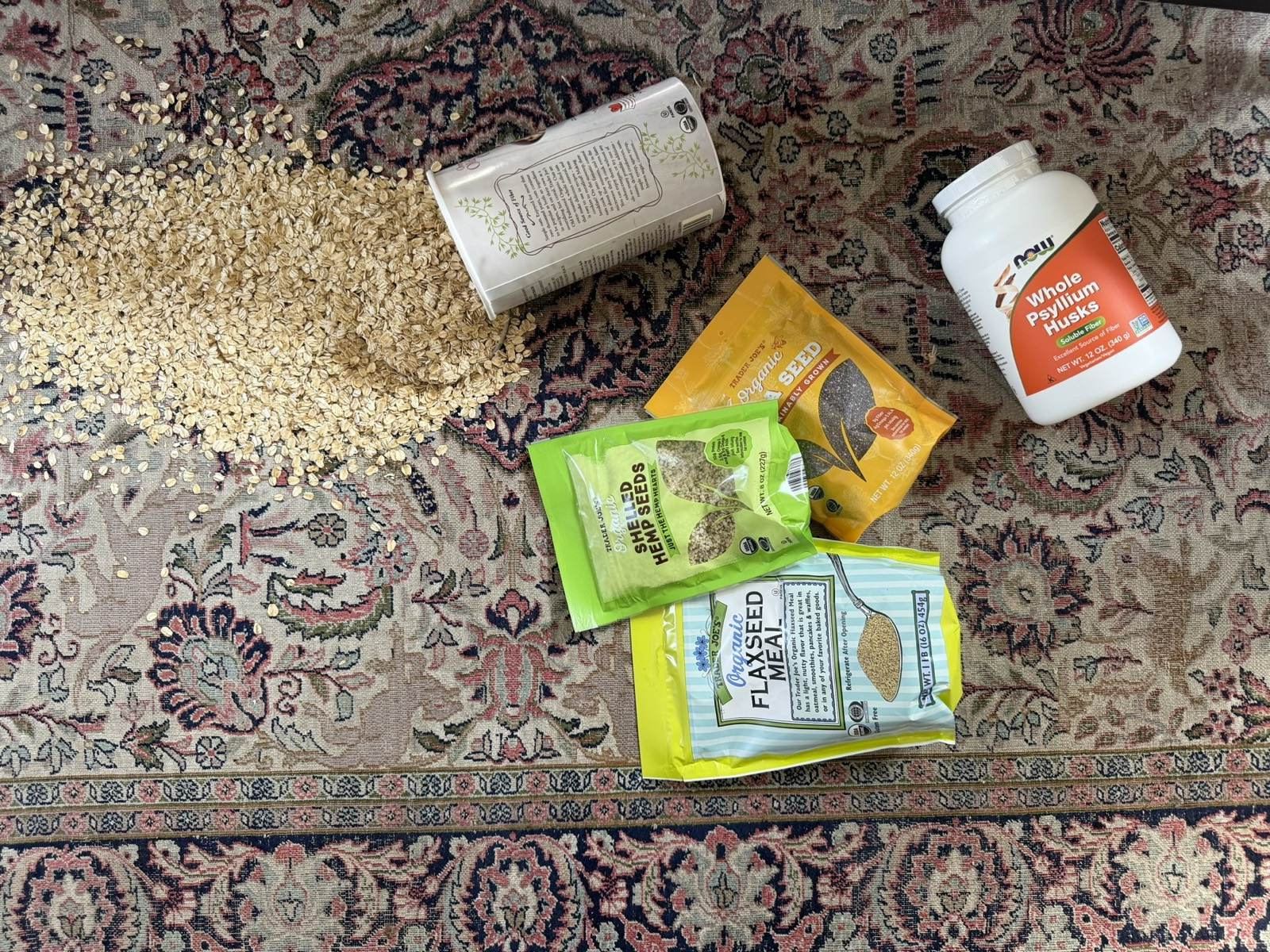 the five sludge ingredients spilled across a rug: oats, chia, hemp hearts, flaxseed meal, psyllium husks